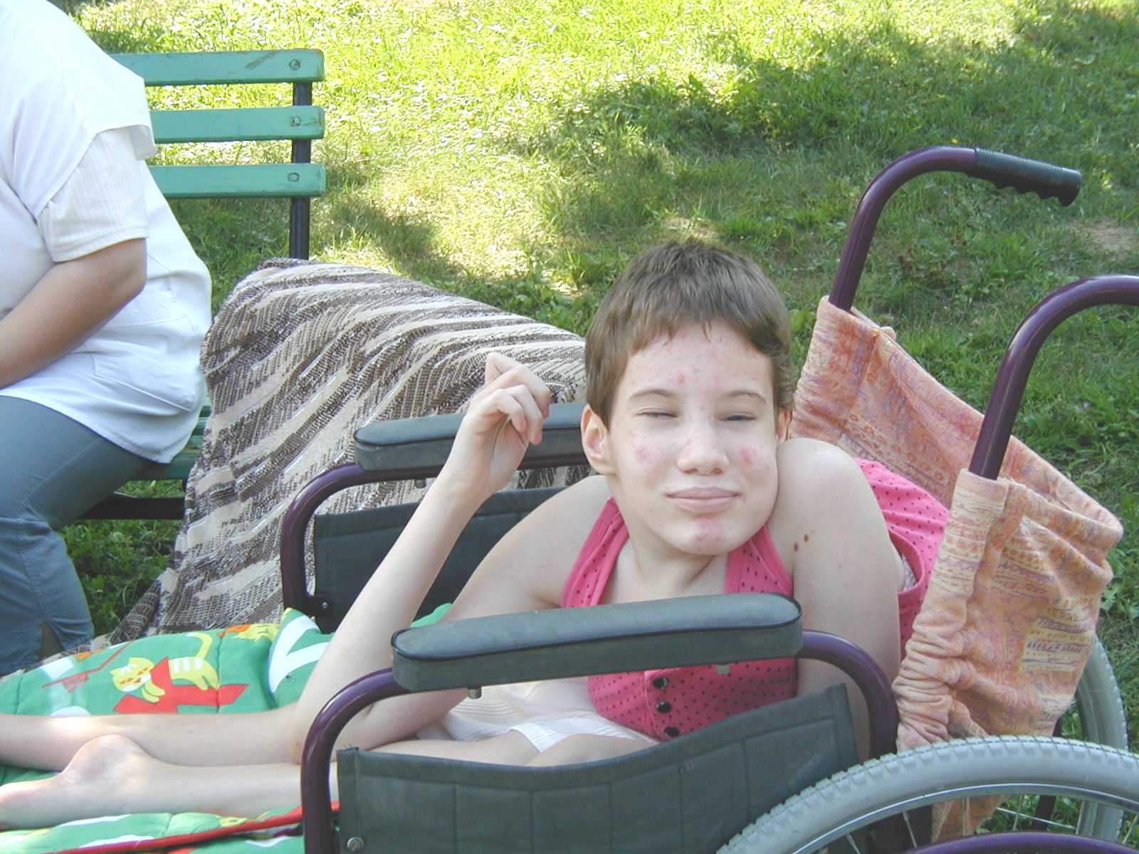 A teenage sitting in a wheelchair provided by Hands that Help.